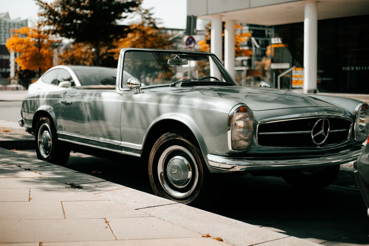 Srebrny zabytkowy Mercedes-Benz SL Pagoda zaparkowany przy ulicy